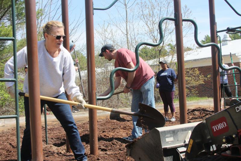 Rhonda Veugen works alongside other volunteers on Sunday to help set up a new playground at Minot Forest Elementary. BY MATTHEW BERNAT